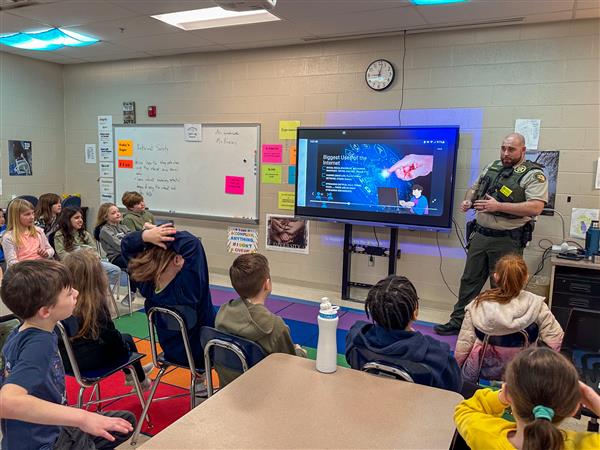 police officer talking to class of students